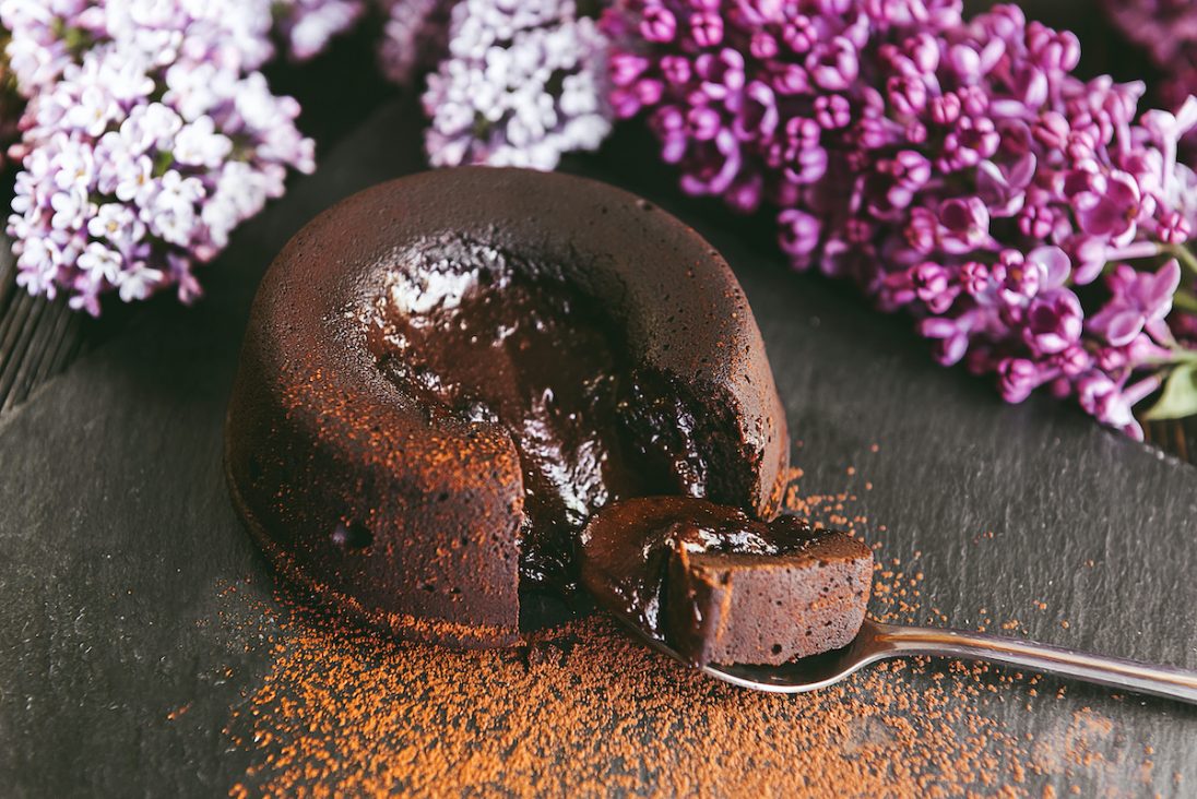 delicious looking lava chocolate cake on the table and flowers behind