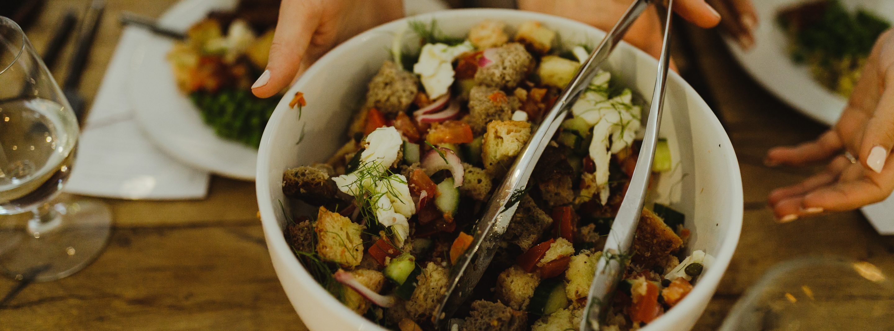 white bowl of salad with hunks of tomatoes, bread and mozarella cheese