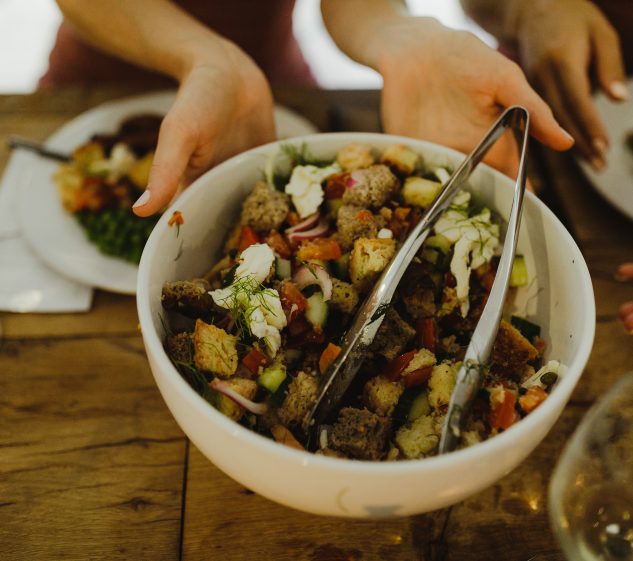 white bowl of salad with hunks of tomatoes, bread and mozarella cheese